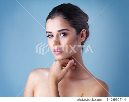 Beauty, skincare and portrait of woman in studio with natural makeup, confidence and luxury cosmetics. Dermatology, facial care and girl with shine, wellness and healthy skin glow on blue background. Beauty, skincare and portrait of woman in studio with natural makeup, confidence and luxury cosmetics. Dermatology, facial care and girl with shine, wellness and healthy skin glow on blue background. 142669744