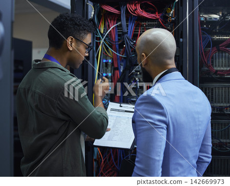 People, paper and technician engineer in server room, cable and programmers with paperwork. Men, colleagues and it support for machine maintenance, processor hardware and teamwork for system 142669973