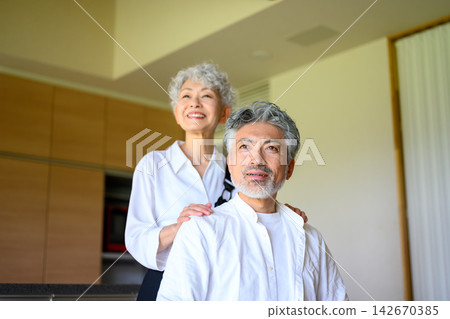 一對老年夫婦在家中面帶微笑，互相依偎，畫面溫馨感人。 142670385