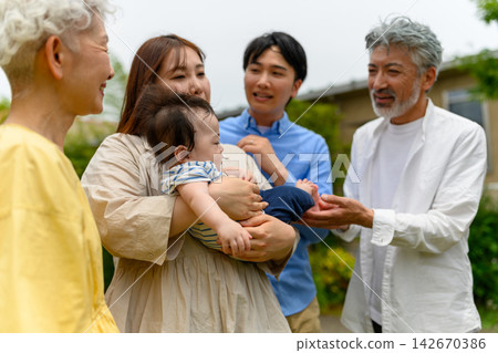 一個溫馨的畫面：三代同堂的家庭微笑著守護著他們的寶寶。 142670386