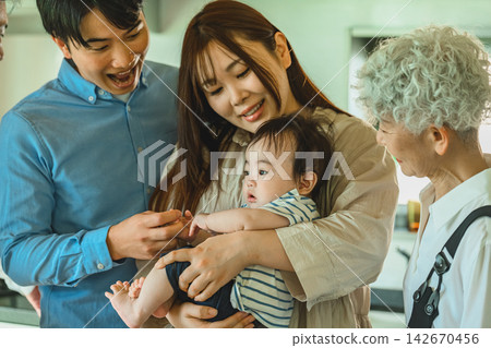一家人面帶微笑地守護著他們的寶寶。 142670456