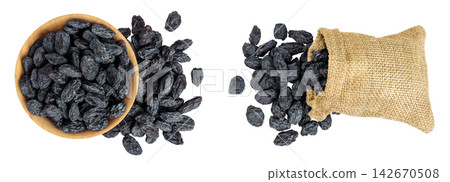 black raisins in bag and wooden bowl isolated on white background. Top view. Flat lay black raisins in bag and wooden bowl isolated on white background. Top view. Flat lay 142670508