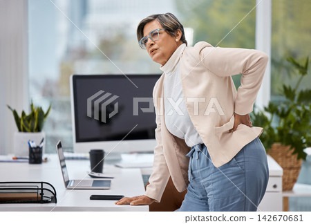 Business woman, back pain and office and with injury, tired and spine problem standing at table. Medical emergency, stress and executive massage for body strain, accident and tension or fatigue Business woman, back pain and office and with injury, tired and spine problem standing at table. Medical emergency, stress and executive massage for body strain, accident and tension or fatigue 142670681