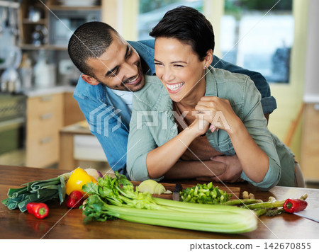 Cooking, smile and couple embrace at kitchen counter for preparation, healthy food and bonding together on date. Vegetables, happy man and vegan woman for dinner, nutrition meal or love in home 142670855