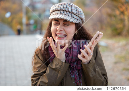 Female celebrating a personal milestone while holding smartphone. Motivation and happiness concept. 142670864