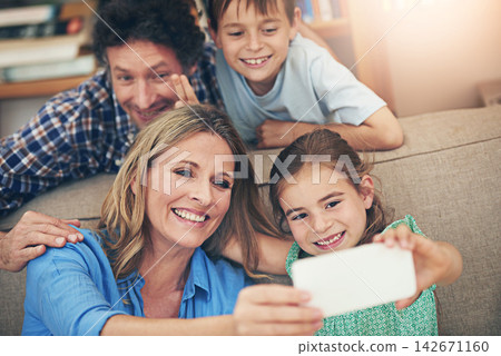 Happy family, relax and selfie with peace sign on sofa for memory, picture or bonding together at home. Mom, dad and young children with smile for photography, capture or moment on living room couch Happy family, relax and selfie with peace sign on sofa for memory, picture or bonding together at home. Mom, dad and young children with smile for photography, capture or moment on living room couch 142671160