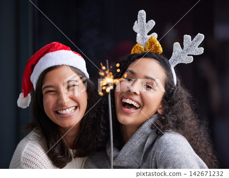 Women, portrait and happy friends for Christmas or holiday with sparks for celebration in home. Party, season and gathering with together for tradition, family and vacation with bonding in Germany. Women, portrait and happy friends for Christmas or holiday with sparks for celebration in home. Party, season and gathering with together for tradition, family and vacation with bonding in Germany. 142671232