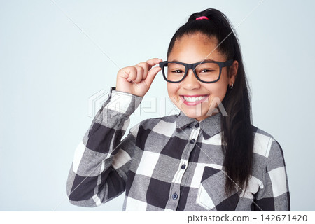 Studio, glasses and portrait of girl with confidence for nerd style, trendy clothes and healthy eyesight. Kid, child and happiness with smile for quirky outfit, fashion and pride on white background Studio, glasses and portrait of girl with confidence for nerd style, trendy clothes and healthy eyesight. Kid, child and happiness with smile for quirky outfit, fashion and pride on white background 142671420