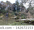 兼六園的池塘上飄落著雪花，樹木也被白雪覆蓋。 142672153