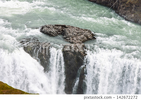 Water flowing over dark volcanic rock at Gullfoss waterfall in wild Icelandic scenery Water flowing over dark volcanic rock at Gullfoss waterfall in wild Icelandic scenery 142672272