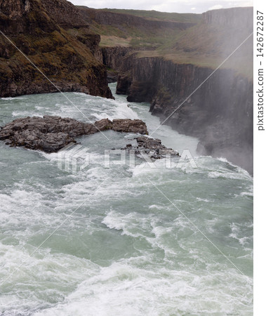 Hvita River at the rocky brink of Gullfoss waterfall in Icelandic wilderness 142672287