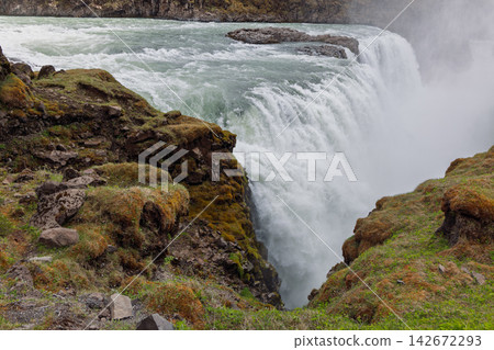 Gullfoss waterfall framed by mossy volcanic rock in the notable Nordic landscape of Iceland Gullfoss waterfall framed by mossy volcanic rock in the notable Nordic landscape of Iceland 142672293