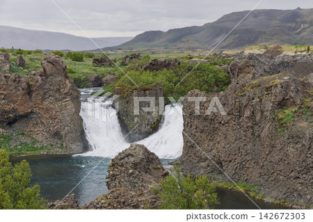 Twin Hjalparfoss waterfall in a rugged lava basin as a natural attraction in Iceland Twin Hjalparfoss waterfall in a rugged lava basin as a natural attraction in Iceland 142672303