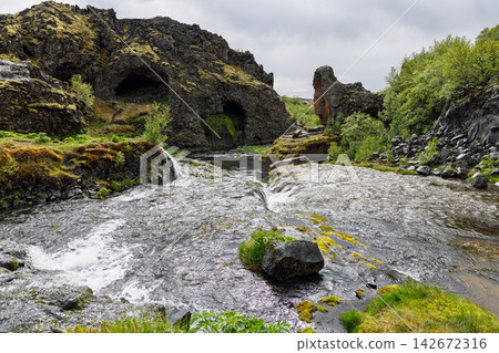 Rauda River flowing through lava formations across Gjain, Iceland, balanced river and lava 142672316