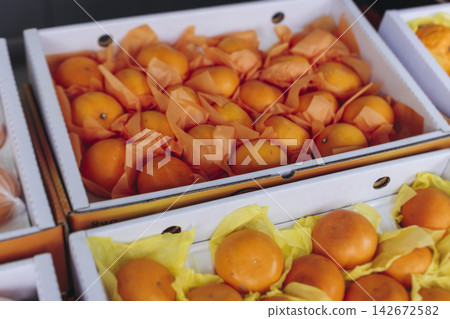 Jeju orange and hallabong for sale on farm market shop, Jeju Island, South Korea, tangerine and gamgyul fruits packed in gift orange boxes and crates, ripe citrus fruits export, Jeju-do agriculture Jeju orange and hallabong for sale on farm market shop, Jeju Island, South Korea, tangerine and gamgyul fruits packed in gift orange boxes and crates, ripe citrus fruits export, Jeju-do agriculture 142672582