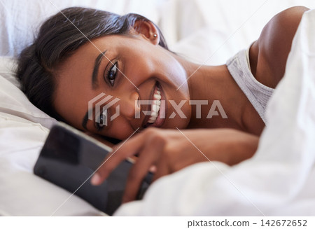 Woman, phone and texting in morning, reading and wake up with smile for notification, chat or online dating in home. Girl, person and happy with smartphone, application and mobile network in bedroom Woman, phone and texting in morning, reading and wake up with smile for notification, chat or online dating in home. Girl, person and happy with smartphone, application and mobile network in bedroom 142672652