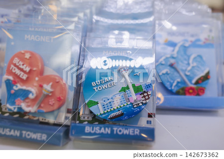 Tourist gifts and Korean souvenirs from Busan, South Korea,  toys and figurines, fridge magnets and key ring keychain, key fobs and postcards with symbols of Busan in a local gift vendor shop market 142673362