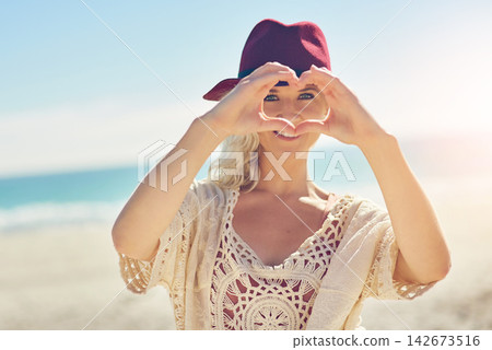 Girl, hands and heart with portrait on beach for visual representation of expression for love, happiness and gratitude. Woman, romantic gesture or symbol and sign of affection, outdoor and support. Girl, hands and heart with portrait on beach for visual representation of expression for love, happiness and gratitude. Woman, romantic gesture or symbol and sign of affection, outdoor and support. 142673516
