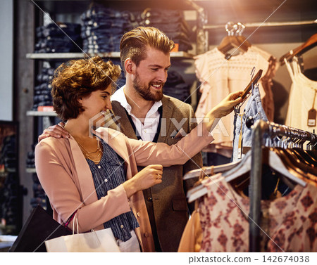 Couple, customer and shopping spree for clothes in shop with choice, retail promotion and happy with store discount. Sale, people and clothing item in mall for buying and fashion deal with bonding Couple, customer and shopping spree for clothes in shop with choice, retail promotion and happy with store discount. Sale, people and clothing item in mall for buying and fashion deal with bonding 142674038