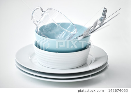 Clean dishes, table and plate stack in studio for lunch isolated on white background in kitchen. Bowl, cup and fresh cutlery pile with knife in restaurant for design, catering or dinner on backdrop Clean dishes, table and plate stack in studio for lunch isolated on white background in kitchen. Bowl, cup and fresh cutlery pile with knife in restaurant for design, catering or dinner on backdrop 142674063
