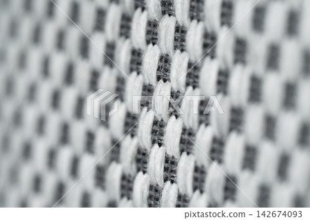Mattress. The background features a macrotexture made of white-and-gray woven fabric. 142674093