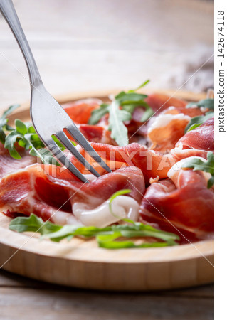 Fork picking sliced serrano ham Fork picking sliced serrano ham 142674118