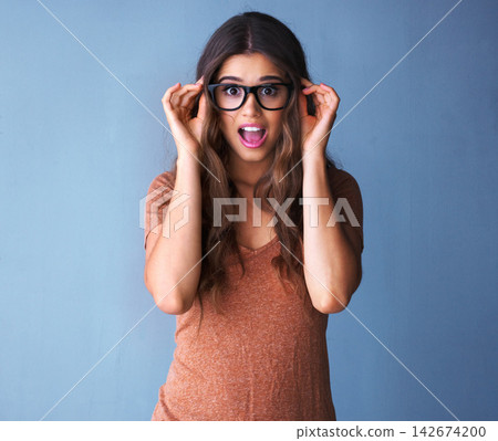 Woman, glasses and surprise in studio portrait, shock and deal for optometry sale with mock up space. Customer, hand gesture for wow expression, promotion and crazy news or announcement offer 142674200
