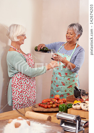 Wine, food and happy senior women in home for toast to lunch, supper and dinner together with friends. Alcohol, cooking and mature people with drink, bottle and glass for celebration, party and event 142674203