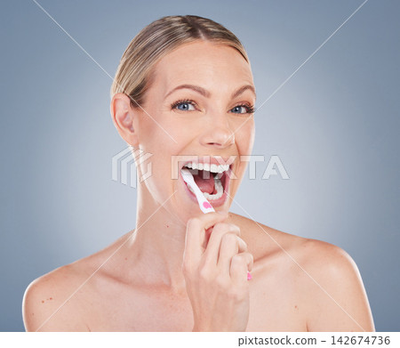 Woman, portrait and brushing teeth in studio with toothbrush, happy and oral hygiene for self care. Mouth, health and cleaning plaque for dental wellness, dentist approved product and fresh breath Woman, portrait and brushing teeth in studio with toothbrush, happy and oral hygiene for self care. Mouth, health and cleaning plaque for dental wellness, dentist approved product and fresh breath 142674736