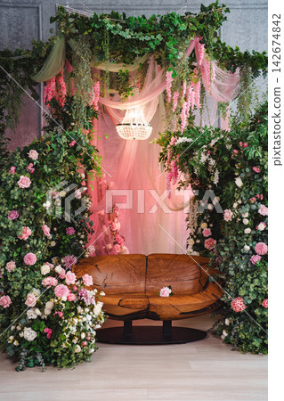 Luxurious floral photo zone setup with wooden seat for wedding celebration Luxurious floral photo zone setup with wooden seat for wedding celebration 142674842