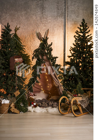 Cozy children's Christmas teepee with fairy lights, wooden sled and holiday decor 142674849
