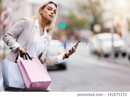 Mobile, shopping and woman waiting for taxi in city for internet deal, search bargain or sale notification. Fashion, retail and customer with smartphone for luxury items, online discount or service Mobile, shopping and woman waiting for taxi in city for internet deal, search bargain or sale notification. Fashion, retail and customer with smartphone for luxury items, online discount or service 142675155