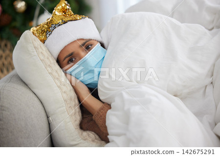 Person, portrait and sick at home on Christmas holiday on sofa with face mask or hat, virus or infection. Woman, tired and couch with blanket for fever or festive season vacation, winter or unhappy Person, portrait and sick at home on Christmas holiday on sofa with face mask or hat, virus or infection. Woman, tired and couch with blanket for fever or festive season vacation, winter or unhappy 142675291