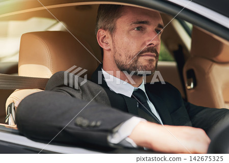 Businessman, thinking and driving in car for travel for commute to corporate work or job as entrepreneur of company. Man, motor vehicle and daily journey with transportation, traffic and on route. Businessman, thinking and driving in car for travel for commute to corporate work or job as entrepreneur of company. Man, motor vehicle and daily journey with transportation, traffic and on route. 142675325