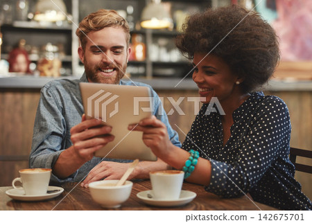 Couple, tablet and laughing on date in coffee shop with social media meme, bonding and funny online information. Interracial, people and happy in cafe with tech app for comic post update and relax Couple, tablet and laughing on date in coffee shop with social media meme, bonding and funny online information. Interracial, people and happy in cafe with tech app for comic post update and relax 142675701