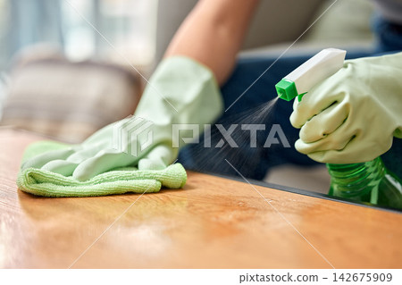 Table, cleaning service and hand of person with bottle for hospitality, work and safety in hygiene. Cloth, spray and cleaner with product in hotel for maintenance, bacteria removal and housekeeping Table, cleaning service and hand of person with bottle for hospitality, work and safety in hygiene. Cloth, spray and cleaner with product in hotel for maintenance, bacteria removal and housekeeping 142675909