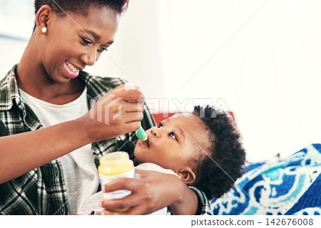 Mom, baby and smile in home with feeding for nutrition, vitamins and growth for child development. Black people, parent and kid or toddler with meal for bonding or care, support and happy with trust Mom, baby and smile in home with feeding for nutrition, vitamins and growth for child development. Black people, parent and kid or toddler with meal for bonding or care, support and happy with trust 142676008
