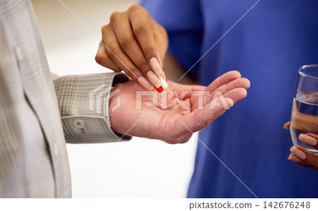 Hands, elderly patient and nurse with pills as medicine, antibiotics and water glass in homecare. Healthcare, Mature man and caregiver for helping, assistance and medication for old person wellness Hands, elderly patient and nurse with pills as medicine, antibiotics and water glass in homecare. Healthcare, Mature man and caregiver for helping, assistance and medication for old person wellness 142676248
