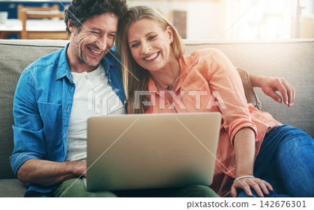 Mature, couple and laughing with laptop in home for comedy movie, funny series or streaming service on sofa. People, technology and comic video on couch with relax, embrace or entertainment in lounge Mature, couple and laughing with laptop in home for comedy movie, funny series or streaming service on sofa. People, technology and comic video on couch with relax, embrace or entertainment in lounge 142676301