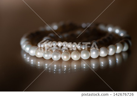 Elegant Pearl Necklace on Dark background, Glass Surface with Reflection. Elegant Pearl Necklace on Dark background, Glass Surface with Reflection. 142676726