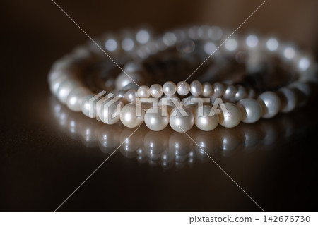 Elegant Pearl Necklace on Dark background, Glass Surface with Reflection. Elegant Pearl Necklace on Dark background, Glass Surface with Reflection. 142676730
