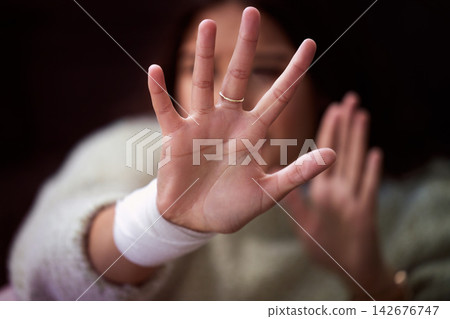 Abuse, domestic violence and hands of woman for self defense in studio on dark background. Scared, stop or victim and person reaching palm to shield from physical danger with fear, horror or stress Abuse, domestic violence and hands of woman for self defense in studio on dark background. Scared, stop or victim and person reaching palm to shield from physical danger with fear, horror or stress 142676747