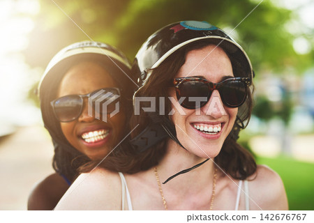 Smile, female couple and motor scooter outside with laugh for fun in summer on holiday or vacation. Lesbian, lgbtq and diverse with women in nature or tourist in London park with closeup in sunshine. Smile, female couple and motor scooter outside with laugh for fun in summer on holiday or vacation. Lesbian, lgbtq and diverse with women in nature or tourist in London park with closeup in sunshine. 142676767