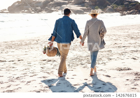 Couple, walking and holding hands on beach, back and holiday at ocean for vacation and adventure. Summer, travel and romantic picnic date with basket in bali, bonding at sea or outdoor on sand Couple, walking and holding hands on beach, back and holiday at ocean for vacation and adventure. Summer, travel and romantic picnic date with basket in bali, bonding at sea or outdoor on sand 142676815