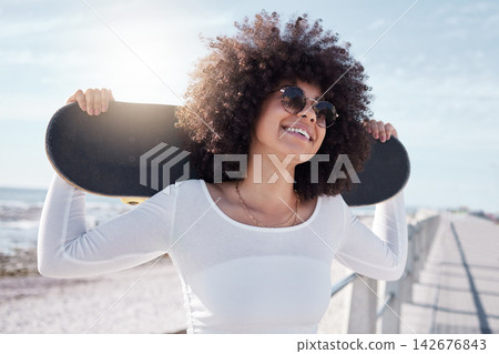 Happy, summer and black woman by sea with skateboard for weekend, holiday and vacation in style. Fashion, laughing and person skateboarding for activity, freedom and adventure by ocean or seaside Happy, summer and black woman by sea with skateboard for weekend, holiday and vacation in style. Fashion, laughing and person skateboarding for activity, freedom and adventure by ocean or seaside 142676843