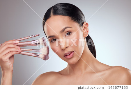 Beauty, blush and makeup brushes with portrait of woman in studio on gray background for cosmetics. Aesthetic, choice or variety and model person with selection of equipment for of cosmetology Beauty, blush and makeup brushes with portrait of woman in studio on gray background for cosmetics. Aesthetic, choice or variety and model person with selection of equipment for of cosmetology 142677163