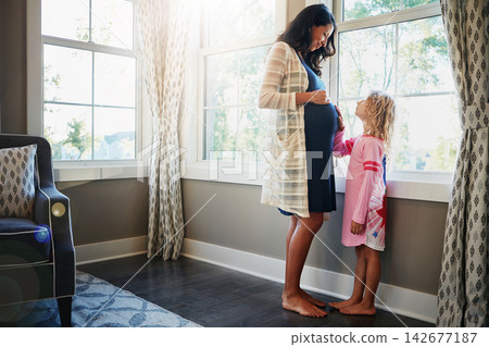 Pregnant, woman and daughter or bonding with stomach for connection, curious and caring for baby in living room. Mother, maternity and touching of tummy for pregnancy growth and development in home Pregnant, woman and daughter or bonding with stomach for connection, curious and caring for baby in living room. Mother, maternity and touching of tummy for pregnancy growth and development in home 142677187