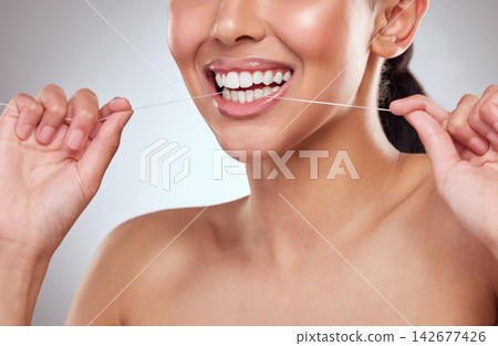 Dental floss, smile or teeth of person closeup in studio on gray background for cleaning and oral hygiene. Dentist, hands and mouth with product for tooth care to prevent cavity, decay or gum disease Dental floss, smile or teeth of person closeup in studio on gray background for cleaning and oral hygiene. Dentist, hands and mouth with product for tooth care to prevent cavity, decay or gum disease 142677426