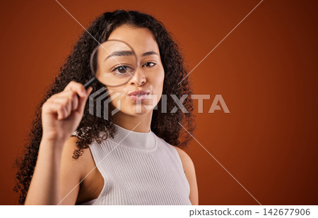 Mockup, portrait and woman in studio with magnifying glass for search, spy and inspection of ideas. Investigation, vision and detective girl with lens for research, focus and review on red background Mockup, portrait and woman in studio with magnifying glass for search, spy and inspection of ideas. Investigation, vision and detective girl with lens for research, focus and review on red background 142677906
