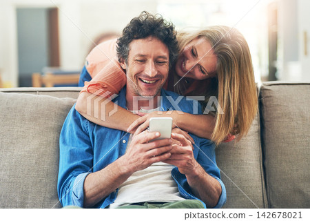 Mature, couple and hug on sofa with phone for reading online news, social media scroll and embrace in home. People, love and laughing with smartphone for funny meme, bingo or digital gaming on couch Mature, couple and hug on sofa with phone for reading online news, social media scroll and embrace in home. People, love and laughing with smartphone for funny meme, bingo or digital gaming on couch 142678021